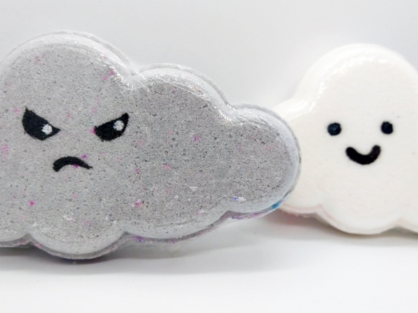 A photo of Grumpy Cloud bath bomb, with a smiley bath bomb in the background.