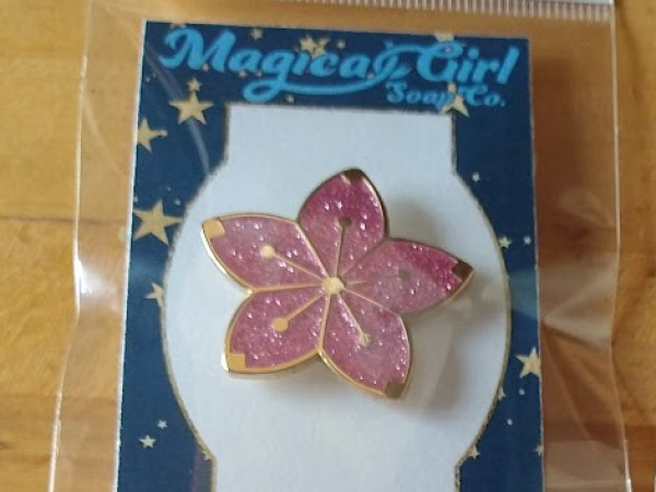 A photo of a cherry blossom/sakura enamel pin.