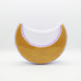 A photo of a golden crescent moon bath bomb.