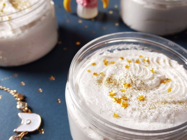 A few jars of white sugar scrub with gold glitter and stars on the top.